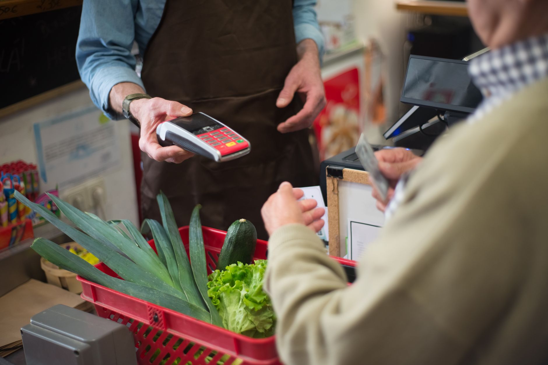 Customer paying for groceries at a store checkout counter.