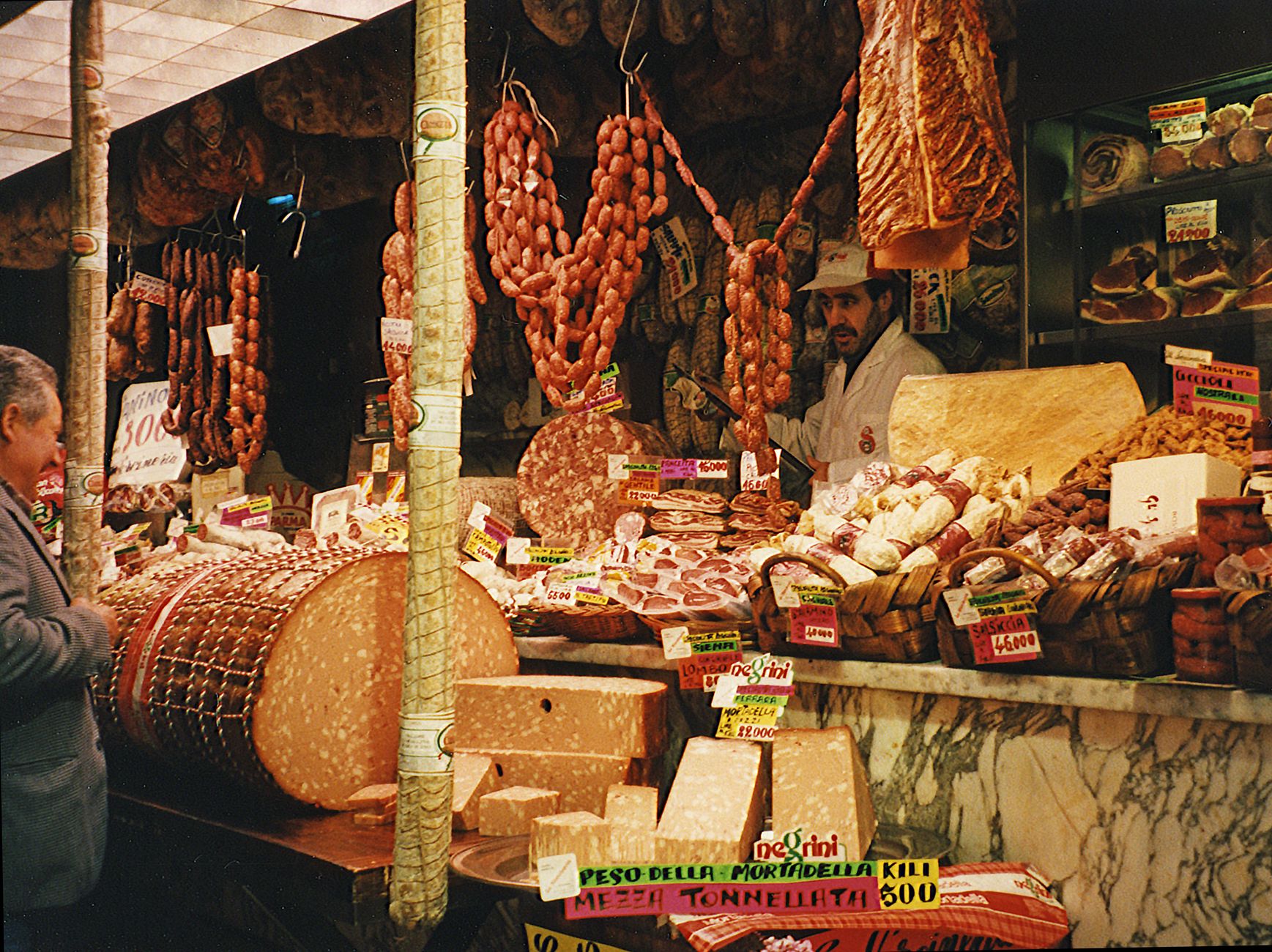 Traditional deli counter showcasing cured meats and cheeses.